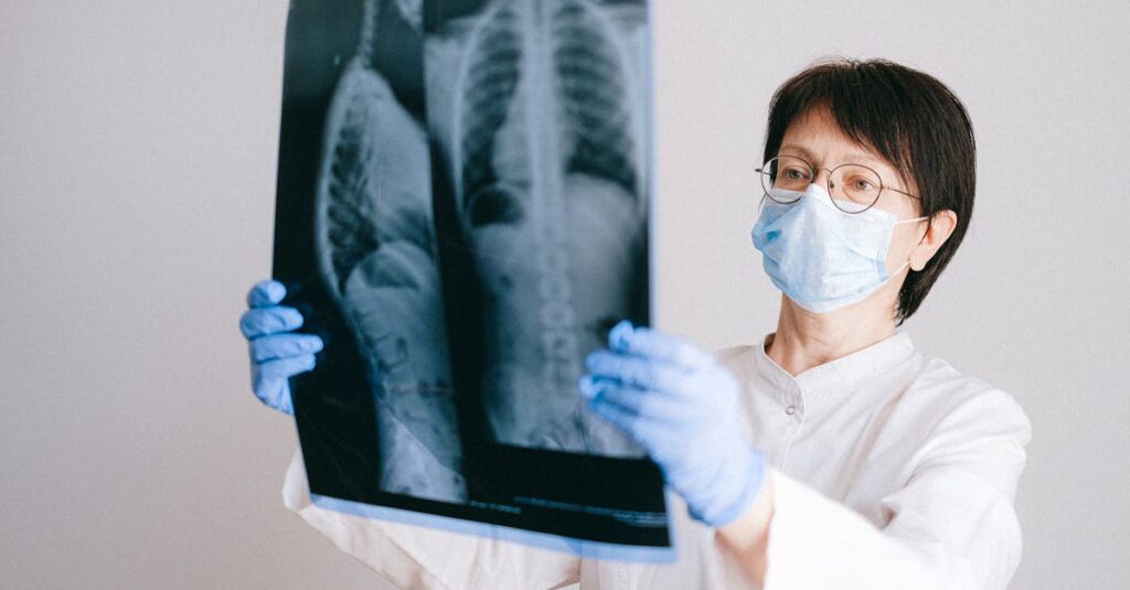 Doctor in protective gear examining chest x-ray for diagnosis.